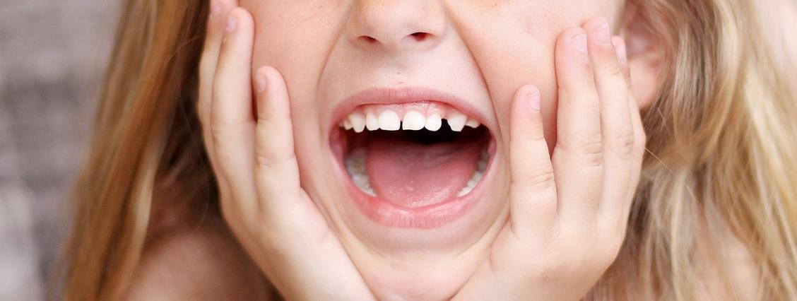 Kind zeigt Zähne